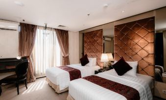 a hotel room with two beds , one on the left and one on the right side of the room at Amaroossa Hotel Bandung Indonesia