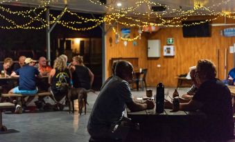 a group of people gathered in a restaurant , enjoying drinks and socializing under a starry ceiling at Discovery Parks - Tannum Sands