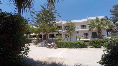 a sunny day at a beach resort , with several people enjoying their time on the sandy shore at Valley Village