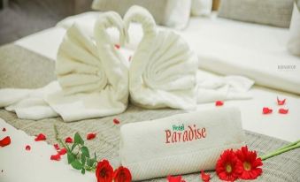 a hotel room with a bed covered in towels , and a bathroom with a bathtub at Hotel Paradise