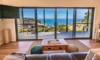 a living room with a large window overlooking the ocean , creating a serene and tranquil atmosphere at Sea Dragon Kangaroo Island