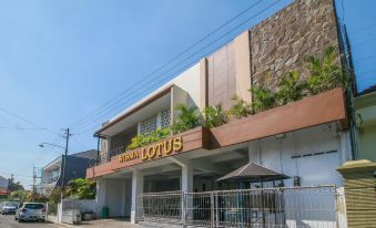 "a building with a sign that says "" ariajus lotus "" and several trees in front of it" at RedDoorz Syariah Near Universitas Jenderal Soedirman