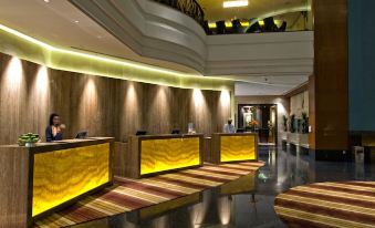A spacious hotel lobby featuring wood paneling and marble countertops on one end at Eastin Hotel Kuala Lumpur