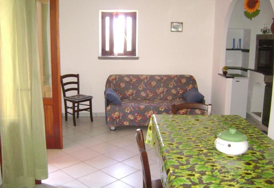 a living room with a couch , chair , and dining table in front of an open doorway at Sweet Home