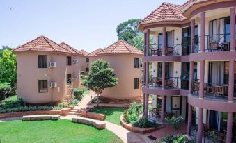 a large apartment complex with multiple buildings and a courtyard , surrounded by greenery and trees at Nile Village Hotel & Spa