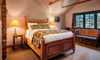 a large bed with a wooden headboard and footboard is in a room with two lamps , a chair , and paintings on the wall at Weasku Inn