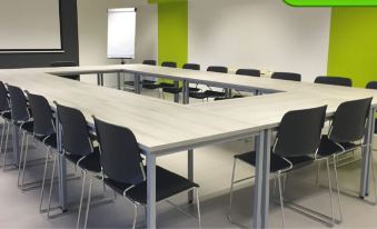 a conference room with a long table and chairs , and a green wall in the background at Arena Boutique Hotel Kuala Terengganu