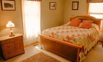 a well - decorated bedroom with a wooden bed , nightstands , and a window , along with some decorative items on the walls at TA Ranch