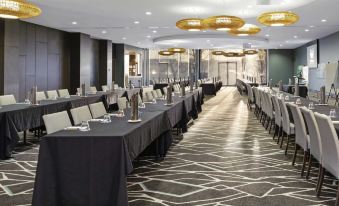 a long dining table set up for a formal event , with numerous chairs arranged around it at Mercure Melbourne Caroline Springs