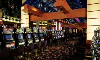 an indoor casino with multiple rows of slot machines and a large table filled with various games at Seneca Allegany Resort & Casino
