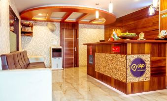 a hotel lobby with a wooden reception desk and a colorful display on the wall at Landmark Hotel