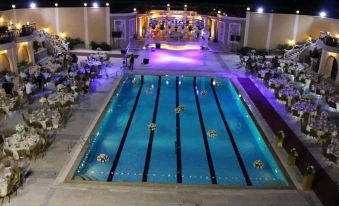 an outdoor pool with a large dance floor and tables set up for an event at Platinum Hotel