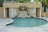 Tropical Oasis w/  pool, gym, king bed, wifi, AC & walk  to restaurants & beach