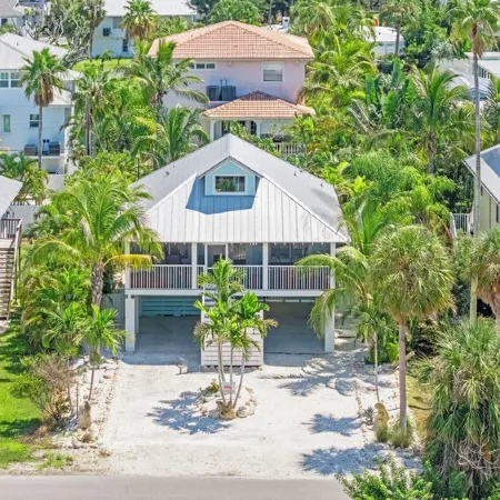 Charming cottage with heated pool, tropical landscaping in prime location.