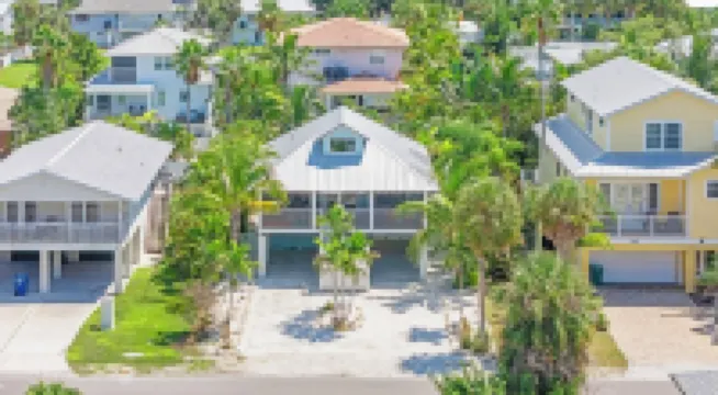 Charming cottage with heated pool, tropical landscaping in prime location.