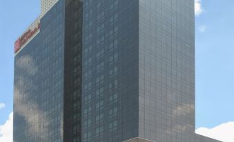 a tall , modern building with blue and gray windows is shown in the daytime at Doubletree by Hilton Istanbul Umraniye