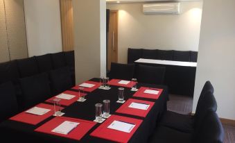 a dining room with a table set for a formal dinner , featuring red place mats and wine glasses at Park Inn by Radisson New Delhi Lajpat Nagar