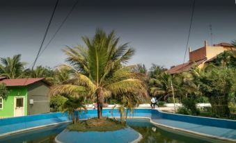 The exotic resort features a central swimming pool surrounded by trees and other plants at Hotel Banalata