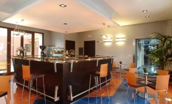 a well - lit bar area with a long wooden bar and several stools for patrons to enjoy drinks at Panorama Hotel