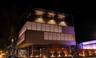 a large , modern building with a modern design and multiple levels of windows at night at Hotel Paradise