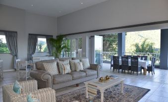 a spacious living room with a couch , chairs , and dining table set up for relaxation and entertainment at The Shore House