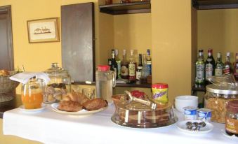 a dining table with a variety of food and drinks , including multiple bottles of liquor at El Castro