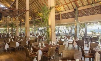 a large dining room with wooden tables and chairs , creating a warm and inviting atmosphere at Barcelo Tambor - All Inclusive