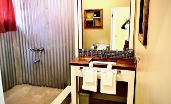 a bathroom sink with a wooden countertop and two towels hanging on the side , next to a shower curtain at The Sea Cliff Hotel Resort & Spa