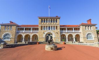 a large , red - brick building with a flag on top and an american flag flying above the entrance , with a statue in front of it at The Civic Hotel