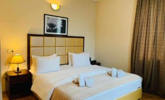 a large bed with white linens and a wooden headboard is in a hotel room at Orion Hotel