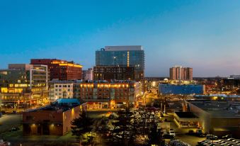a city skyline at dusk , with tall buildings and lights illuminating the surrounding area , creating a vibrant atmosphere at Bethesda North Marriott Hotel & Conference Center