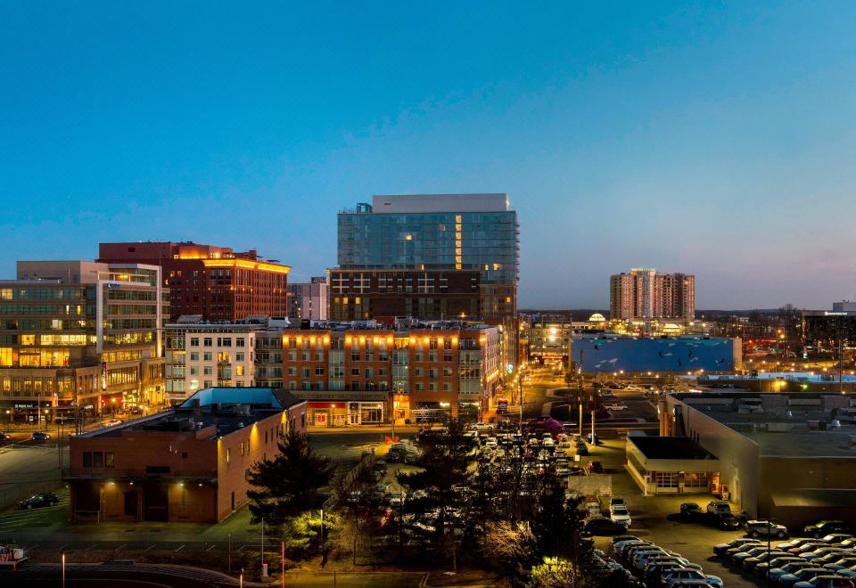 a city skyline at dusk , with tall buildings and lights illuminating the surrounding area , creating a vibrant atmosphere at Bethesda North Marriott Hotel & Conference Center