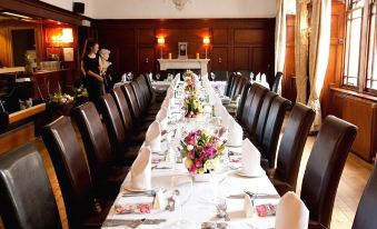 a long dining table set for a formal event , with multiple chairs arranged around it at County Hotel
