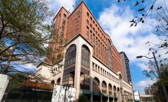 a large brick building with a clock on the side , located in a city setting at Sol Hotel