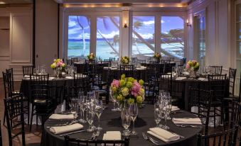a large dining room with round tables set for a formal event , featuring black chairs and flowers in the center at Hotel NoMa, Trademark Collection by Wyndham