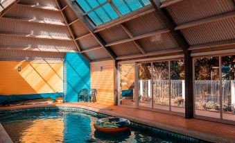 an indoor swimming pool with a boat floating on the water , surrounded by a glass wall at Waterfront Retreat at Wattle Point