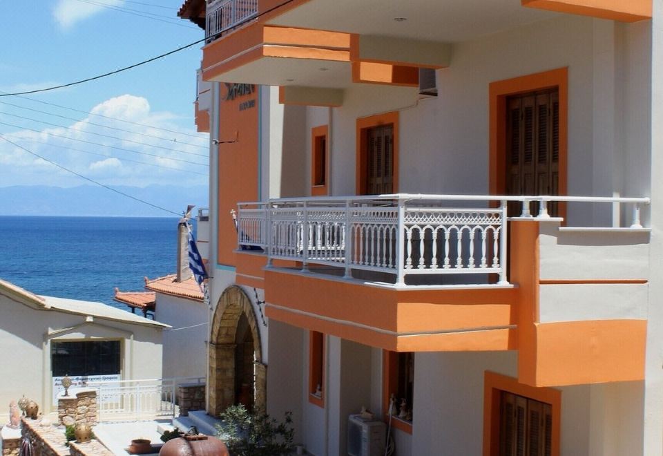 a multi - story building with orange and white exterior , balconies , and a view of the ocean at Sofotel