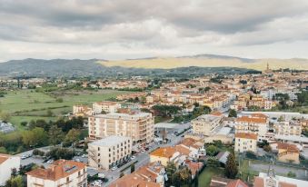 a panoramic view of a city with buildings , roads , and mountains in the background , under a cloudy sky at Hotel Minerva