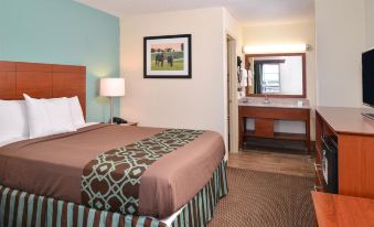 a bedroom with a bed , nightstand , and lamp , as well as a bathroom visible through a doorway at SureStay Hotel by Best Western Bowling Green North