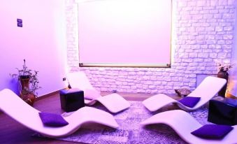 a modern living room with a large screen , white furniture , and purple lights , emphasizing the comfort and style of the space at Hotel Centrale