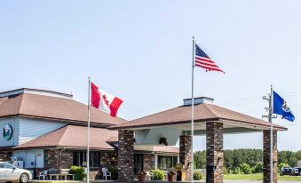 a large building with two flags flying in front of it , one on the left side and the other on the right side at Quality Inn & Suites