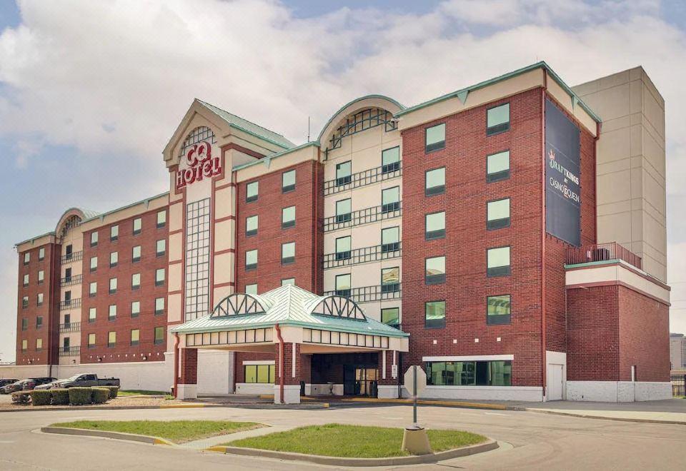 "a large hotel with a red brick exterior and a green roof has the name "" holiday inn "" on it" at Casino Queen Hotel