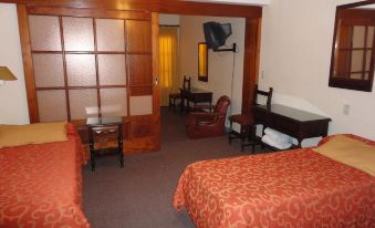 a hotel room with two beds , a desk , and a chair , along with a tv and other amenities at Hotel Presidente