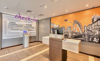 a modern office interior with a large orange roller coaster mural on the wall , a check - in counter , and various office supplies at Premier Inn Hereford City Centre (Old Market)