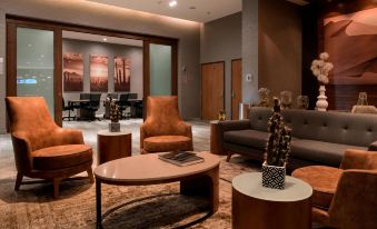a spacious living room with various seating arrangements , including couches , chairs , and a dining table at Courtyard Ciudad Juarez
