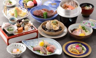 a dining table with a variety of dishes , including sushi , rice , and other food items at IMABARI KOKUSAI HOTEL