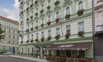 a large green building with many windows , possibly a hotel or restaurant , situated on a city street at Green Garden Hotel