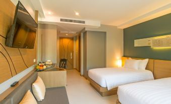 a modern hotel room with two beds , a couch , and a tv , all decorated in white and beige colors at AVA SEA Resort Krabi