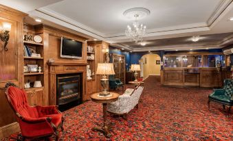 a hotel lobby with a fireplace , couches , chairs , and a television mounted on the wall at Best Western White House Inn