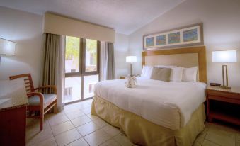 a well - lit hotel room with a large bed , white sheets , and a view of the city through the window at Park Royal Homestay Club Cala Puerto Rico